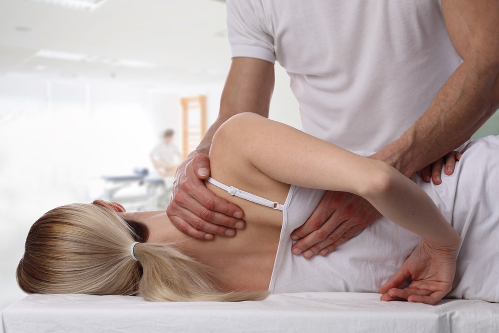 Osteopath providing treatment to young woman